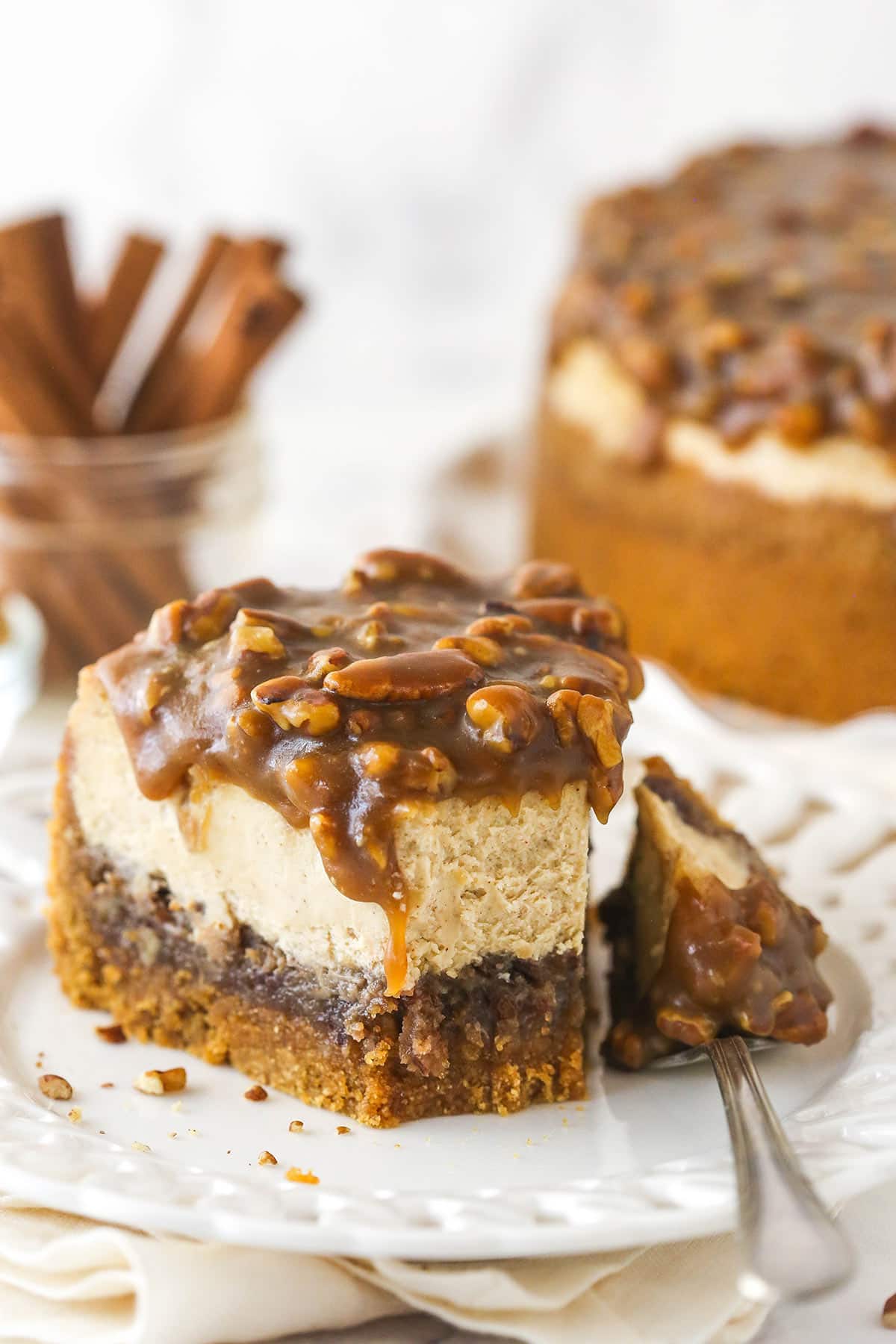 A fork taking a bite out of pecan pie cheesecake.