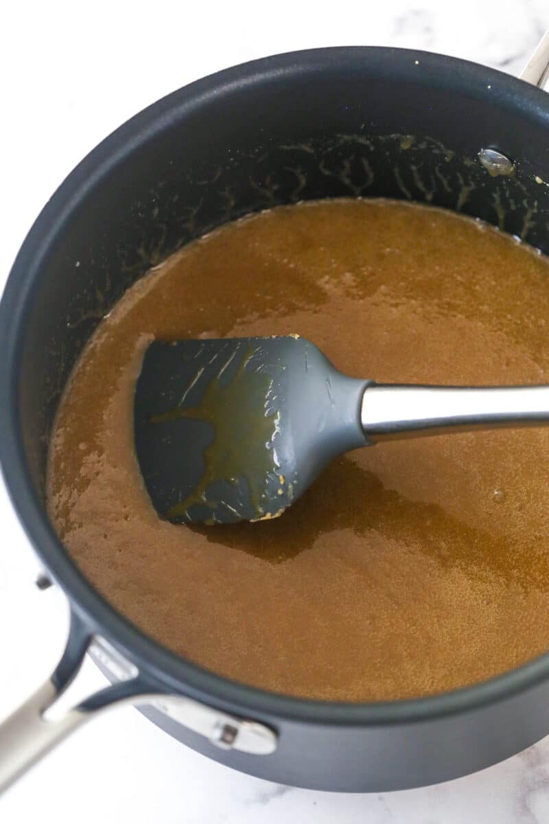 Cream, butter, brown sugar and corn syrup being mixed in a saucepan.