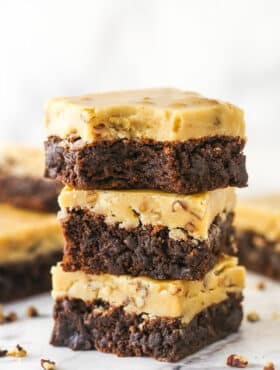 A stack of 3 Praline Pecan Brownies with a bite removed from top brownie.