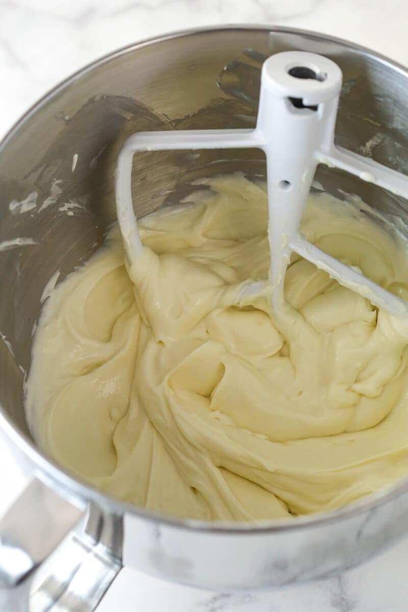 Mixing sour cream and vanilla into cheesecake batter.