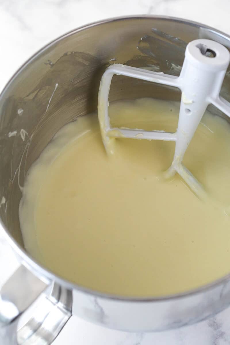 Mixing eggs into cheesecake batter.