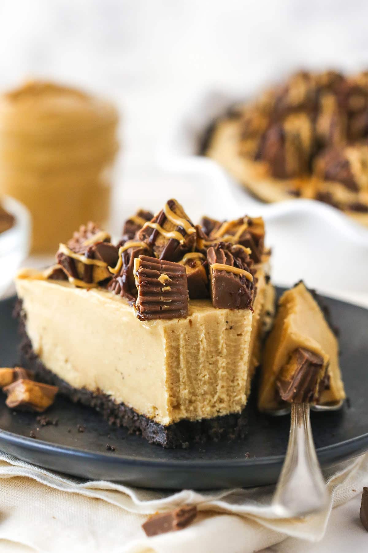 A fork taking a bite out of a slice of Reese's peanut butter pie.