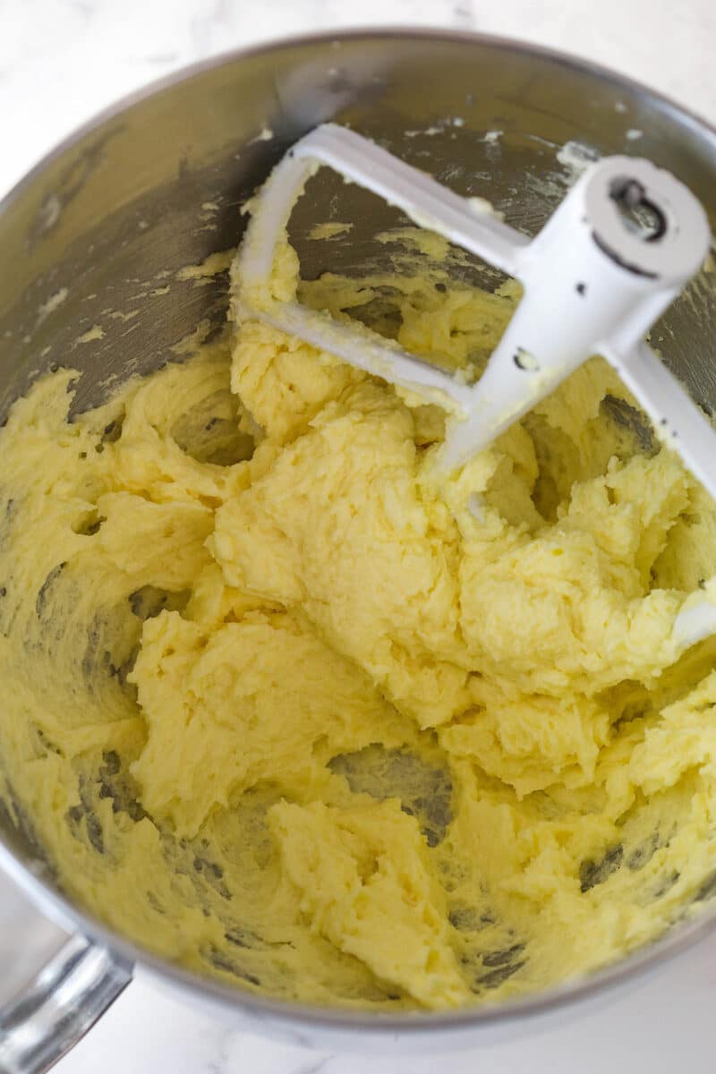 Adding eggs and vanilla to cookie dough.