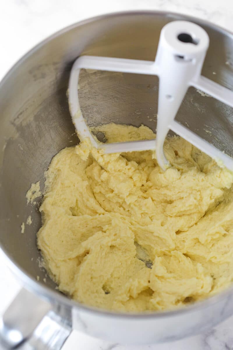 Adding the egg to creamed butter, sugar, and vanilla to make cookie dough.