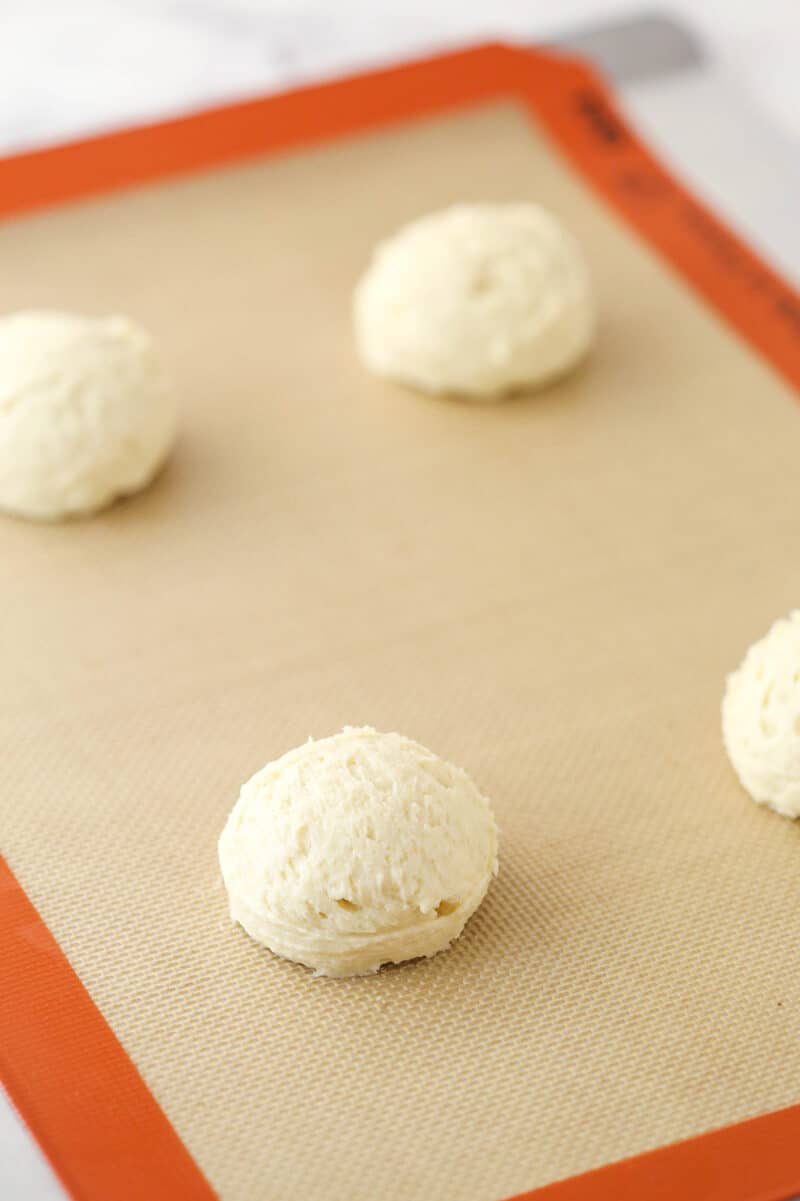 Half moon cookie dough on a silicon baking mat ready to be baked.