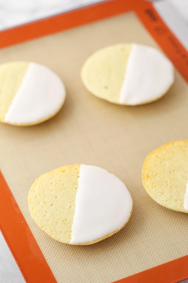 Adding the white frosting to black and white cookies.
