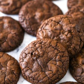 Brownie cookies scattered on a marble surface.