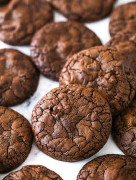 Brownie cookies scattered on a marble surface.