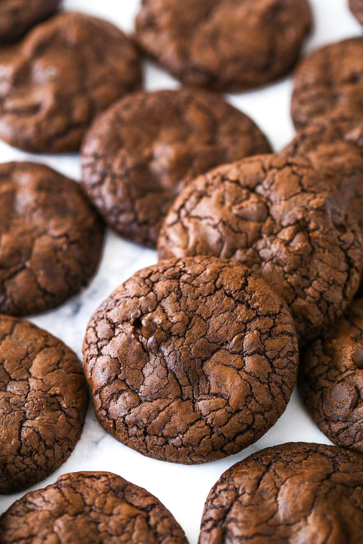 Brownie cookies scattered on a marble surface.