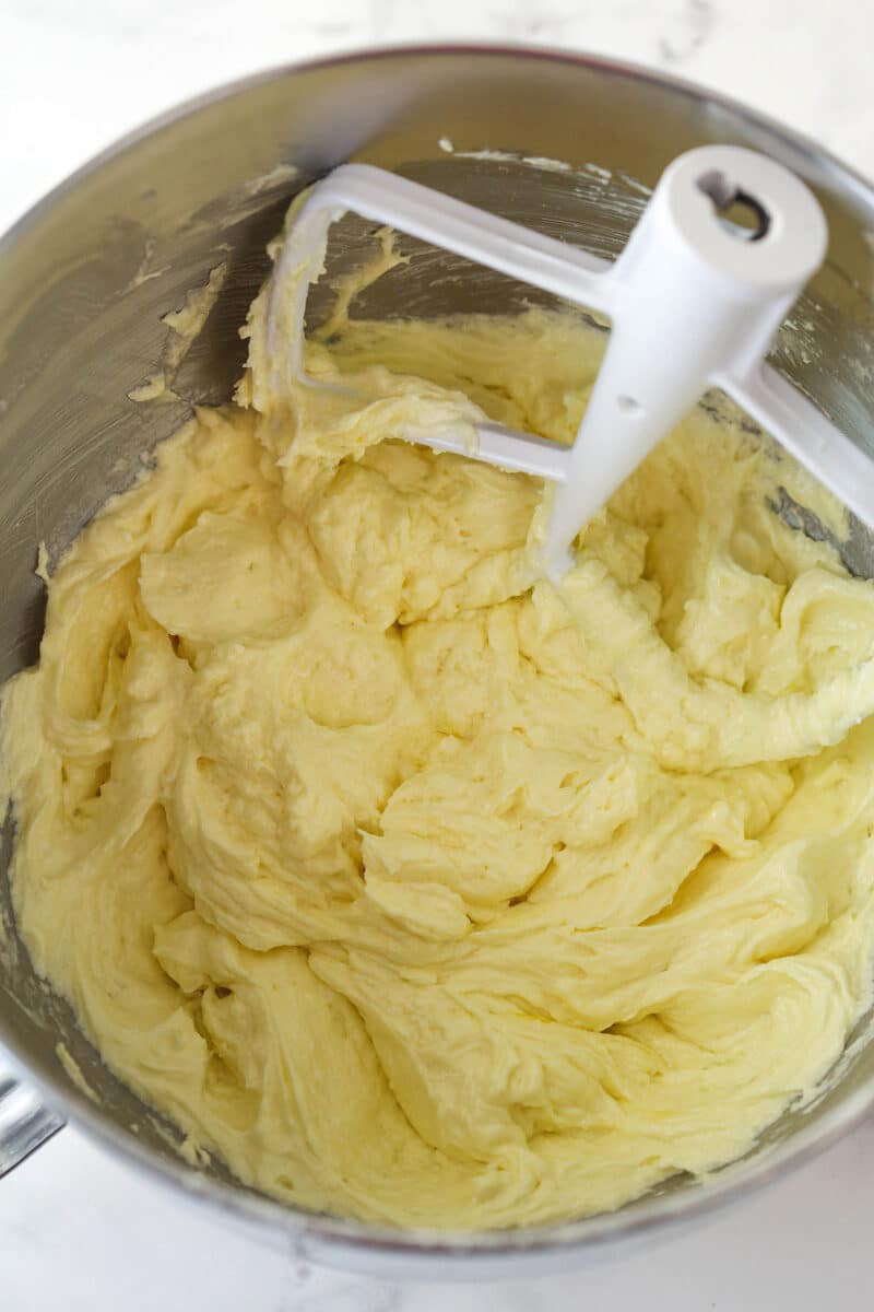 Creamed butter and sugar in a silver mixing bowl after eggs are added.