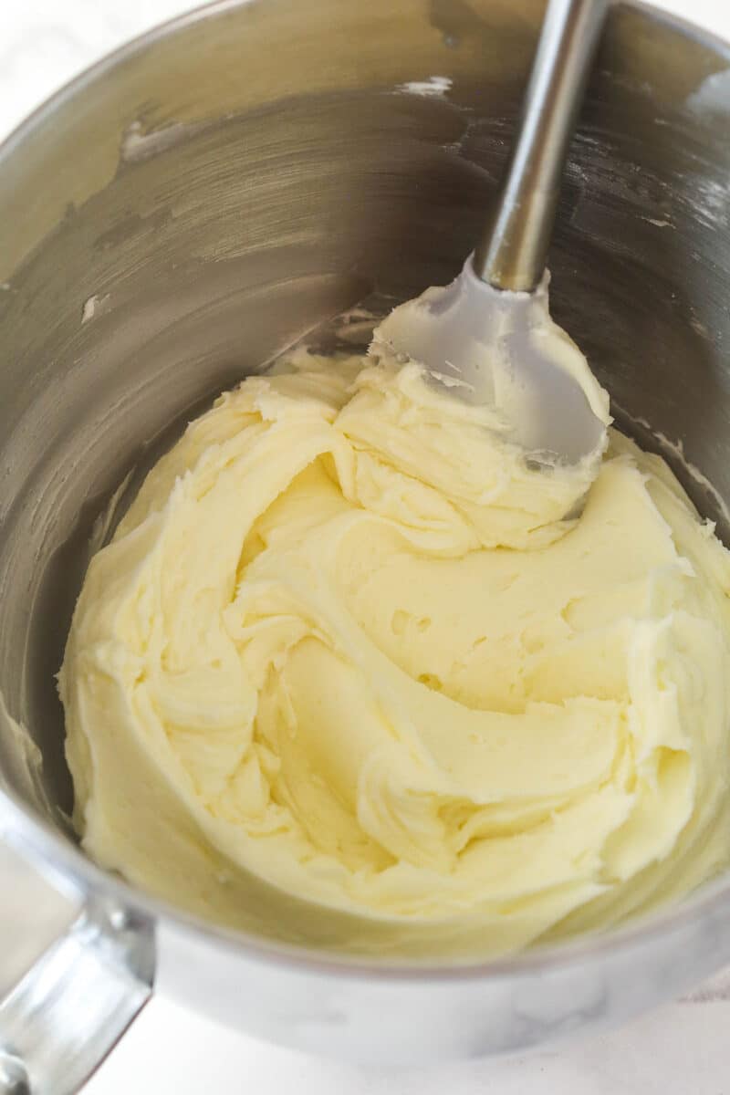 Buttercream frosting in a silver mixing bowl.