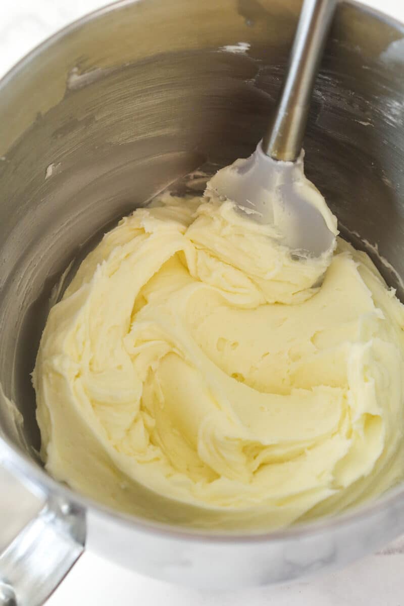 Buttercream frosting in a silver mixing bowl.