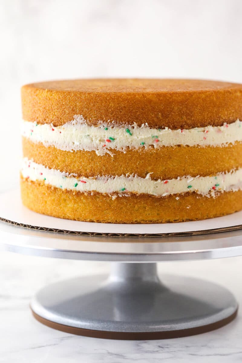 3 layers of cake with frosting and sprinkles on the inside.