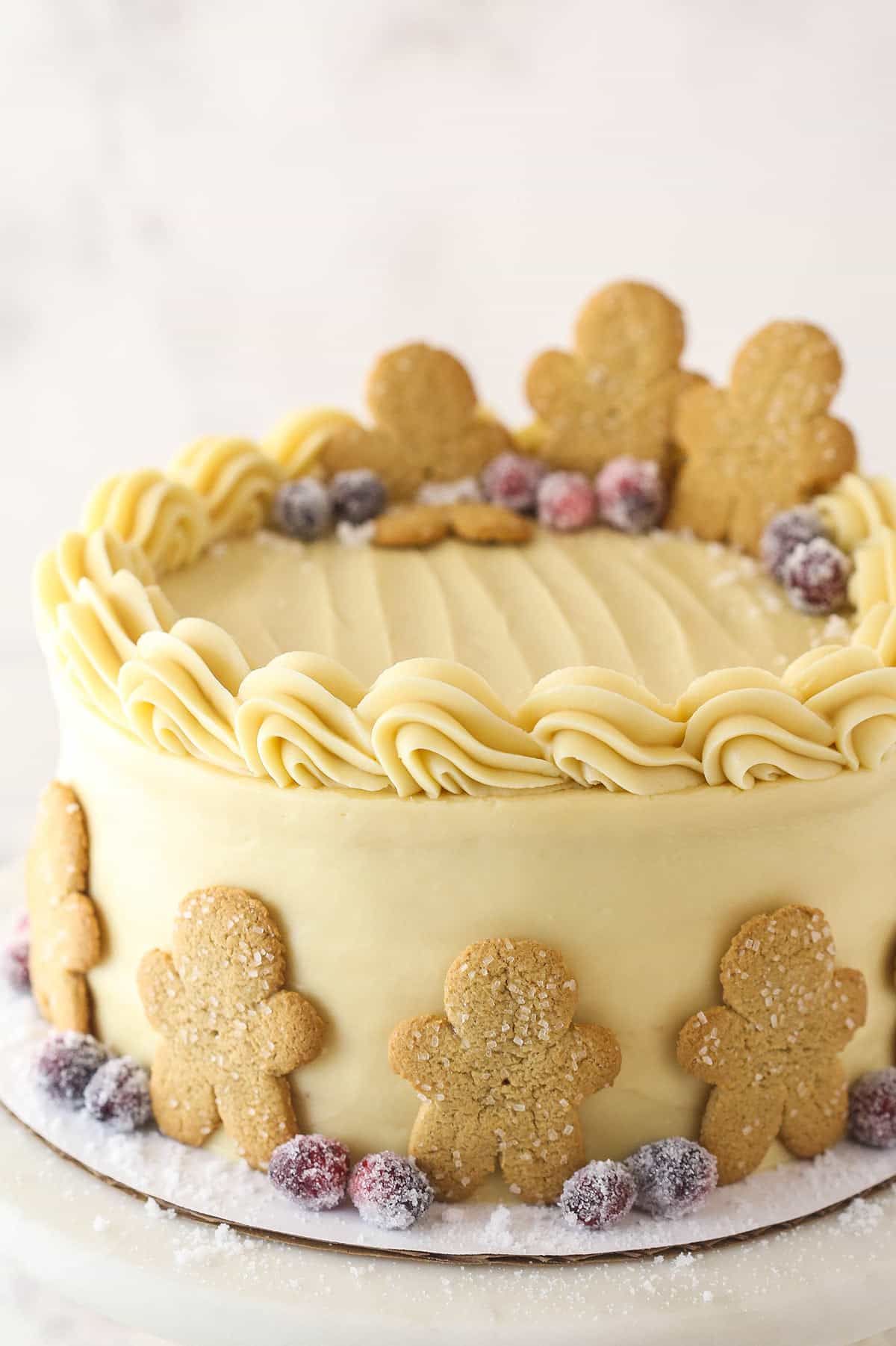 Gingerbread layer cake garnished with gingerbread men and sugared cranberries.