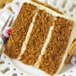 A slice of gingerbread layer cake on a plate with a fork.