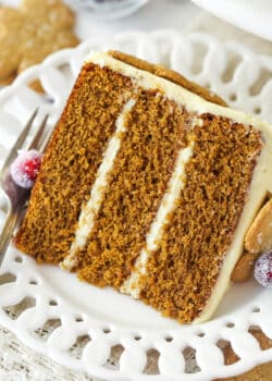 A slice of gingerbread layer cake on a plate with a fork.