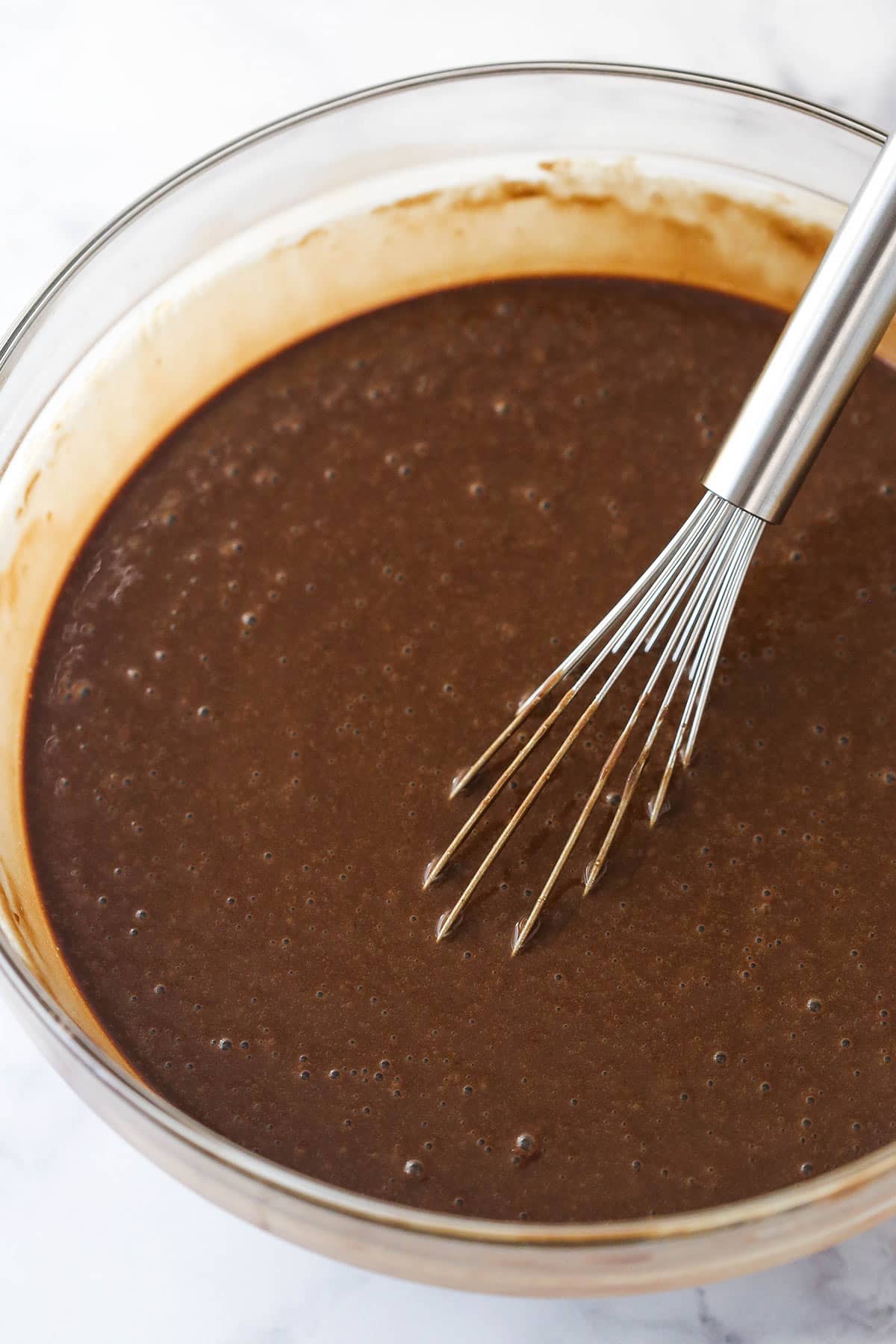 Whisking the vanilla and hot water into chocolate cake batter.