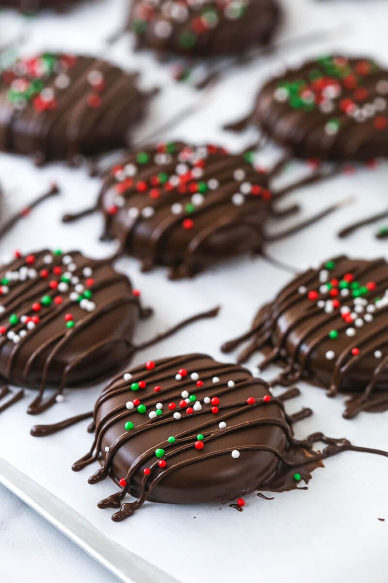 Drizzling extra chocolate and sprinkles over chocolate-dipped peppermint patties.