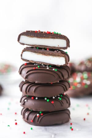 A stack of peppermint patties. The top patty is cut in half.