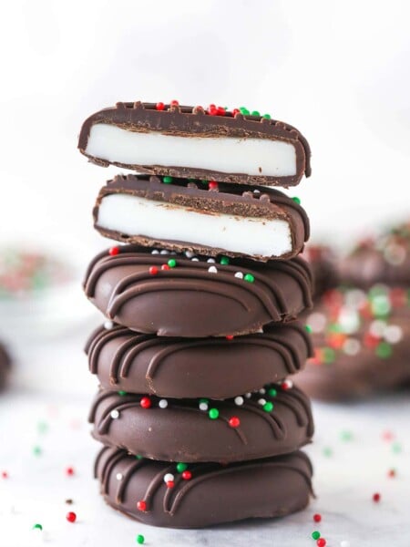 A stack of peppermint patties. The top patty is cut in half.
