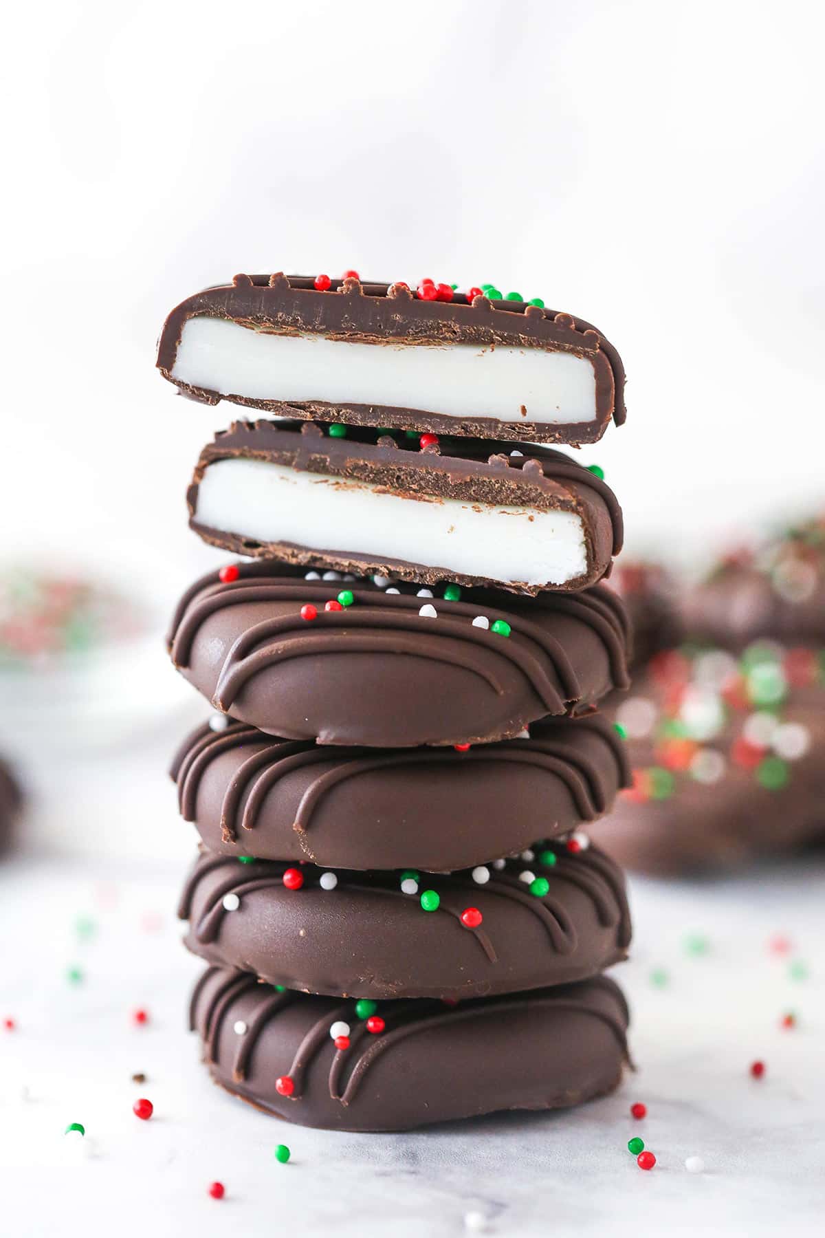 A stack of peppermint patties. The top patty is cut in half.