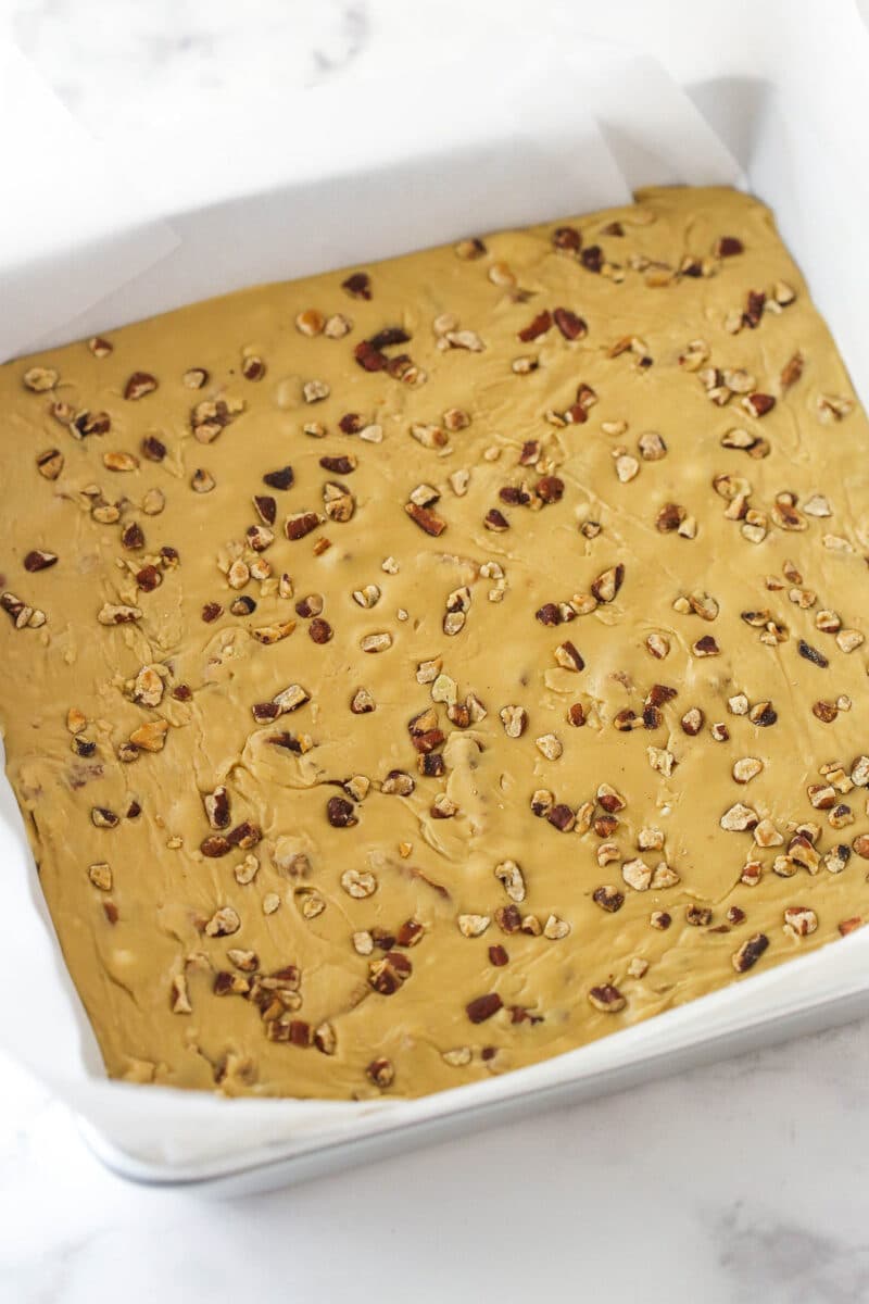 Praline Pecan Fudge pressed into a baking pan.