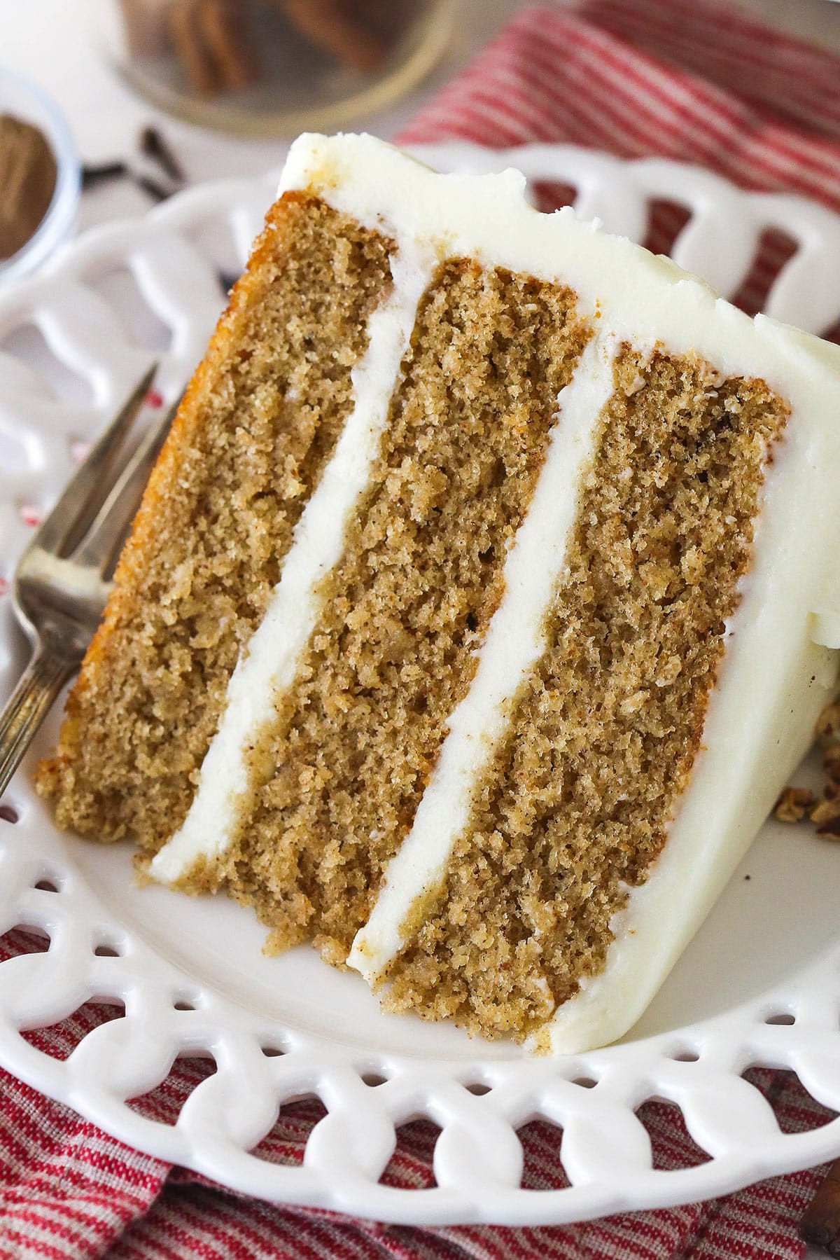 A slice of Spice Cake on a white ruffled plate.
