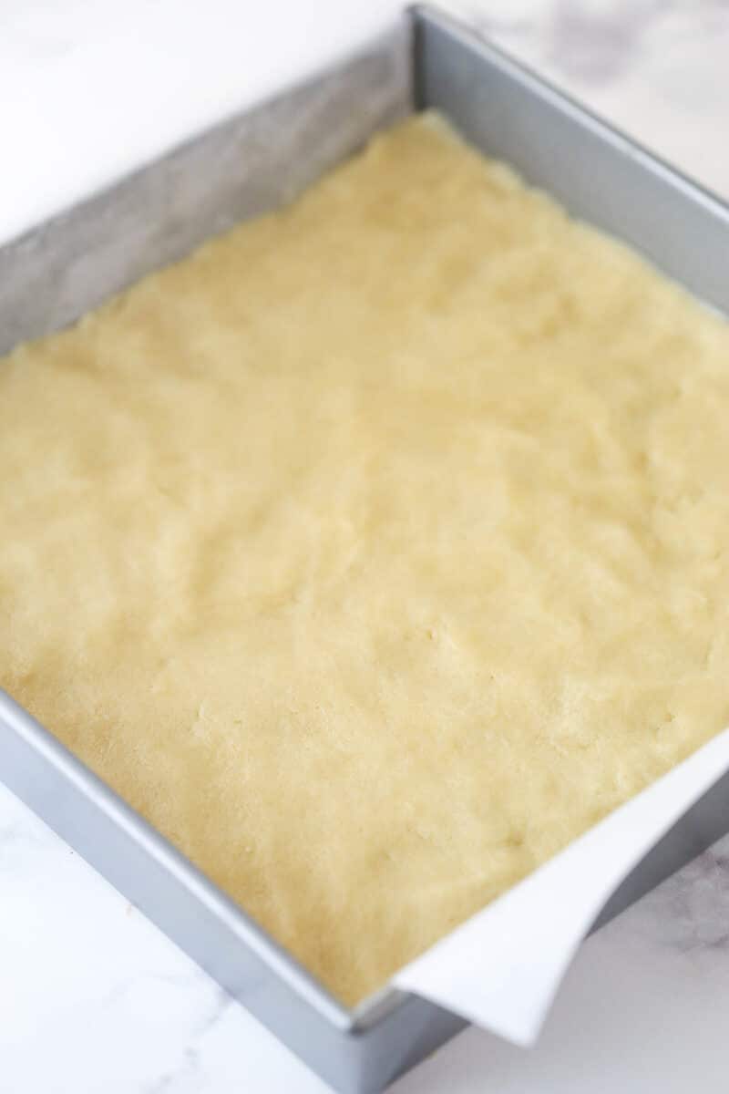 Sugar cookie bar dough in a baking pan.