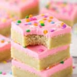 A stack of sugar cookie bars. The top one has a bite taken out of it.