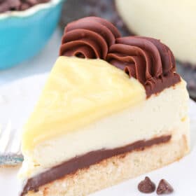 A slice of Boston Cream Pie Cheesecake on a small white plate.