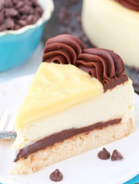 A slice of Boston Cream Pie Cheesecake on a small white plate.