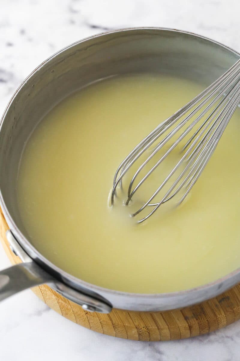 Champagne topping in a small saucepan with a wire wisk.