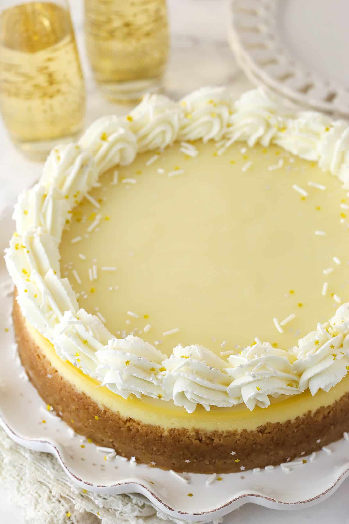 Champagne Cheesecake on a white ruffled plate.