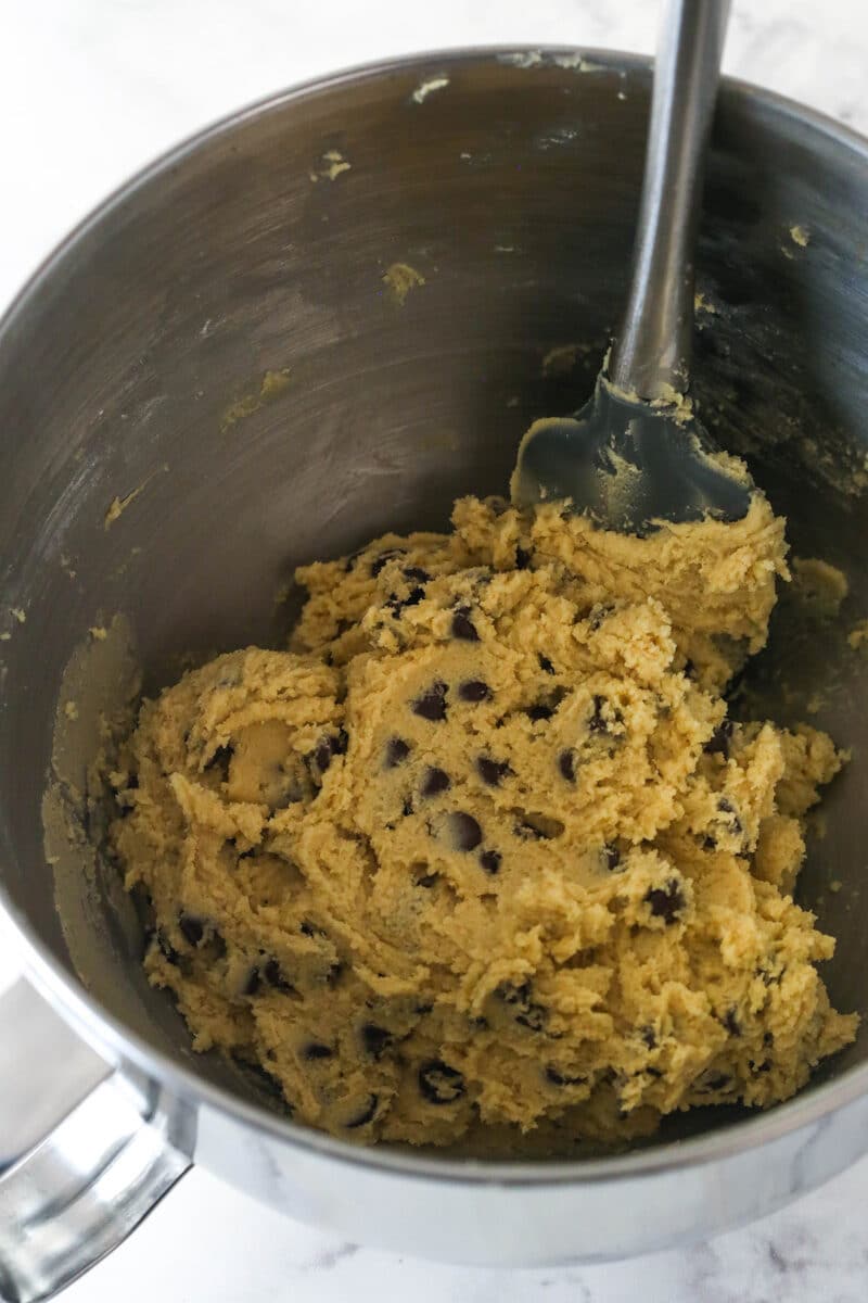 Chocolate chip cookie cake is so moist and chewy and is absolutely loaded with chocolate chips. It's even topped with chocolate buttercream! Mixing chocolate chips into cookie dough.