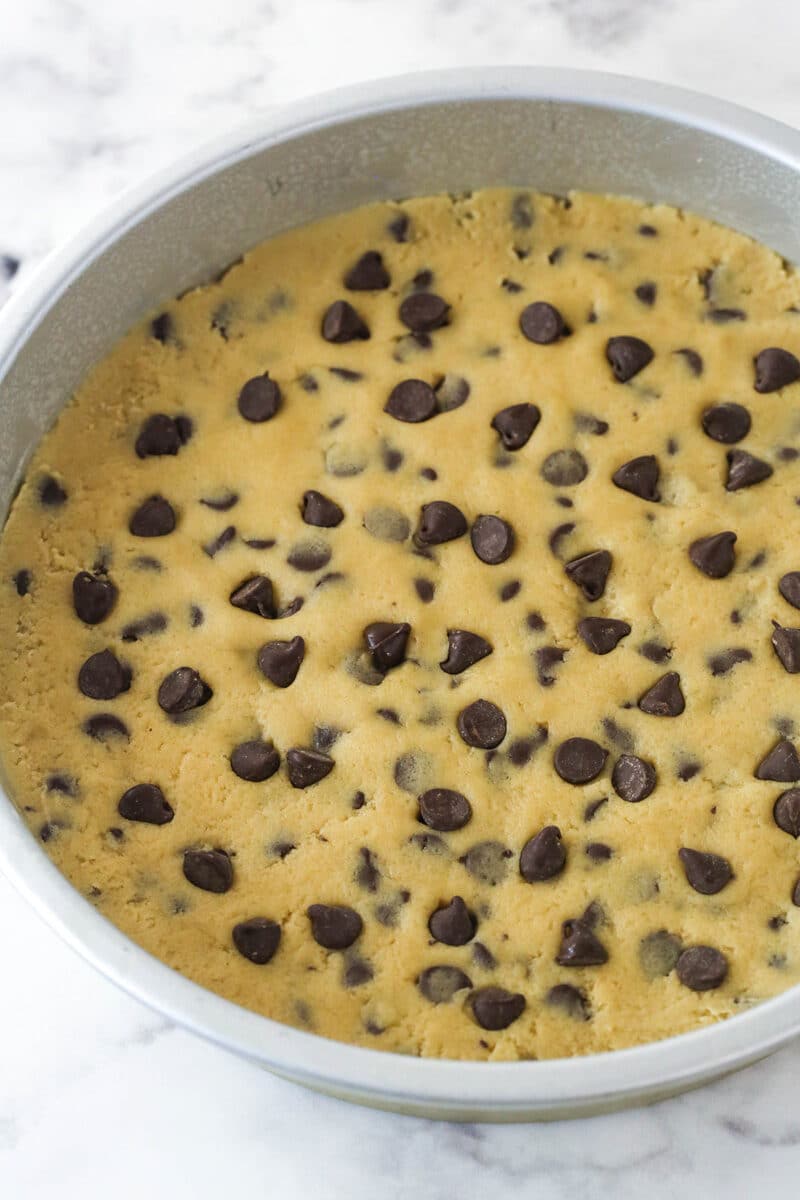 Chocolate chip cookie cake is so moist and chewy and is absolutely loaded with chocolate chips. It's even topped with chocolate buttercream! Chocolate chip cookie dough in a cake pan.