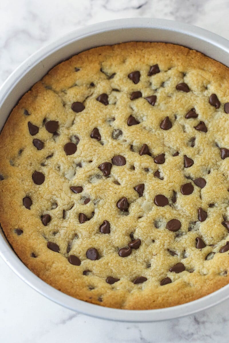 Chocolate chip cookie cake is so moist and chewy and is absolutely loaded with chocolate chips. It's even topped with chocolate buttercream! Chocolate chip cookie cake cooling in the pan.
