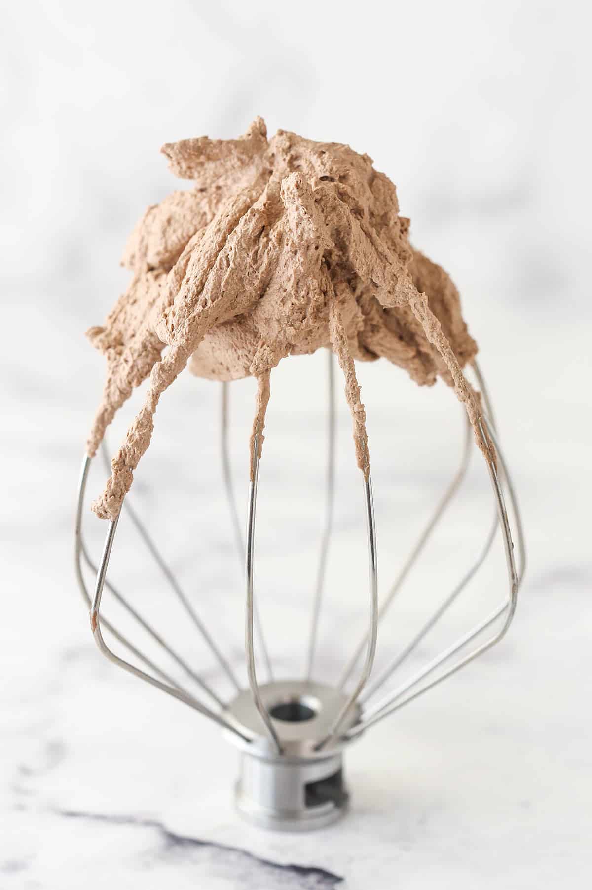 Chocolate whipped cream on a whisk.