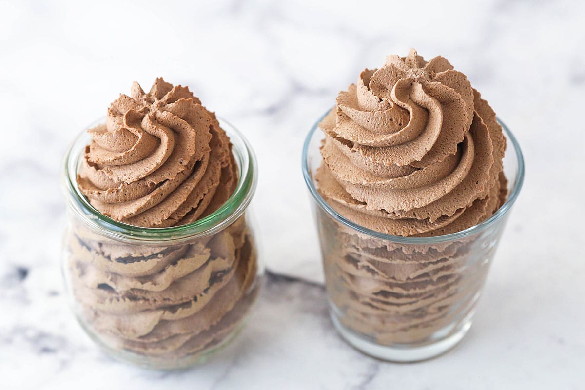 Overhead image of 2 jars of chocolate whipped cream; one made with granulated sugar and one made with powdered sugar.