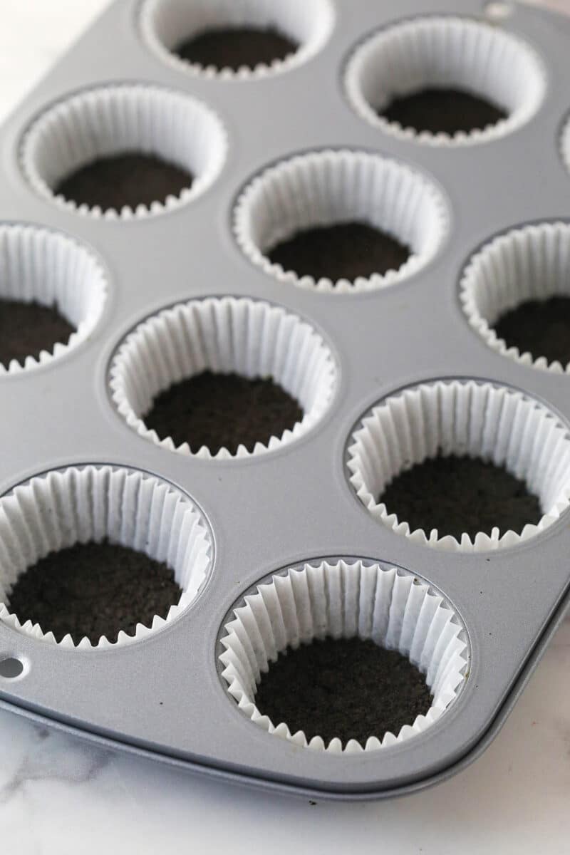 Oreo crust pressed into cupcake liners.