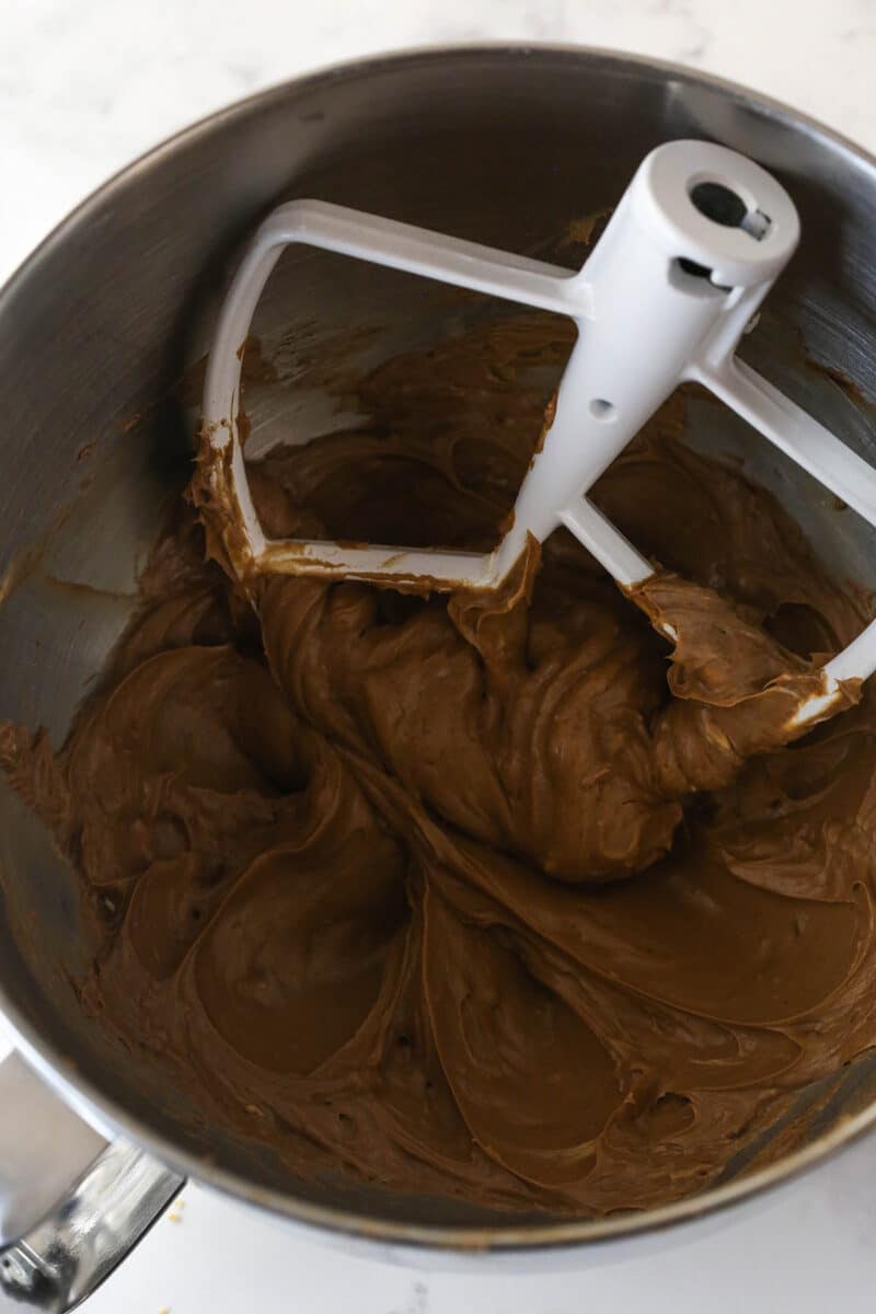 Mixing together cream cheese, sugar, and cocoa powder.