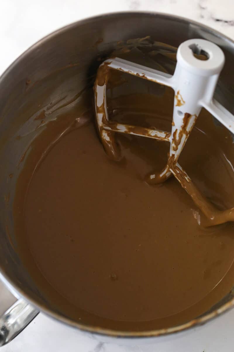 Mixing sour cream, vanilla, and eggs into chocolate cheesecake batter.