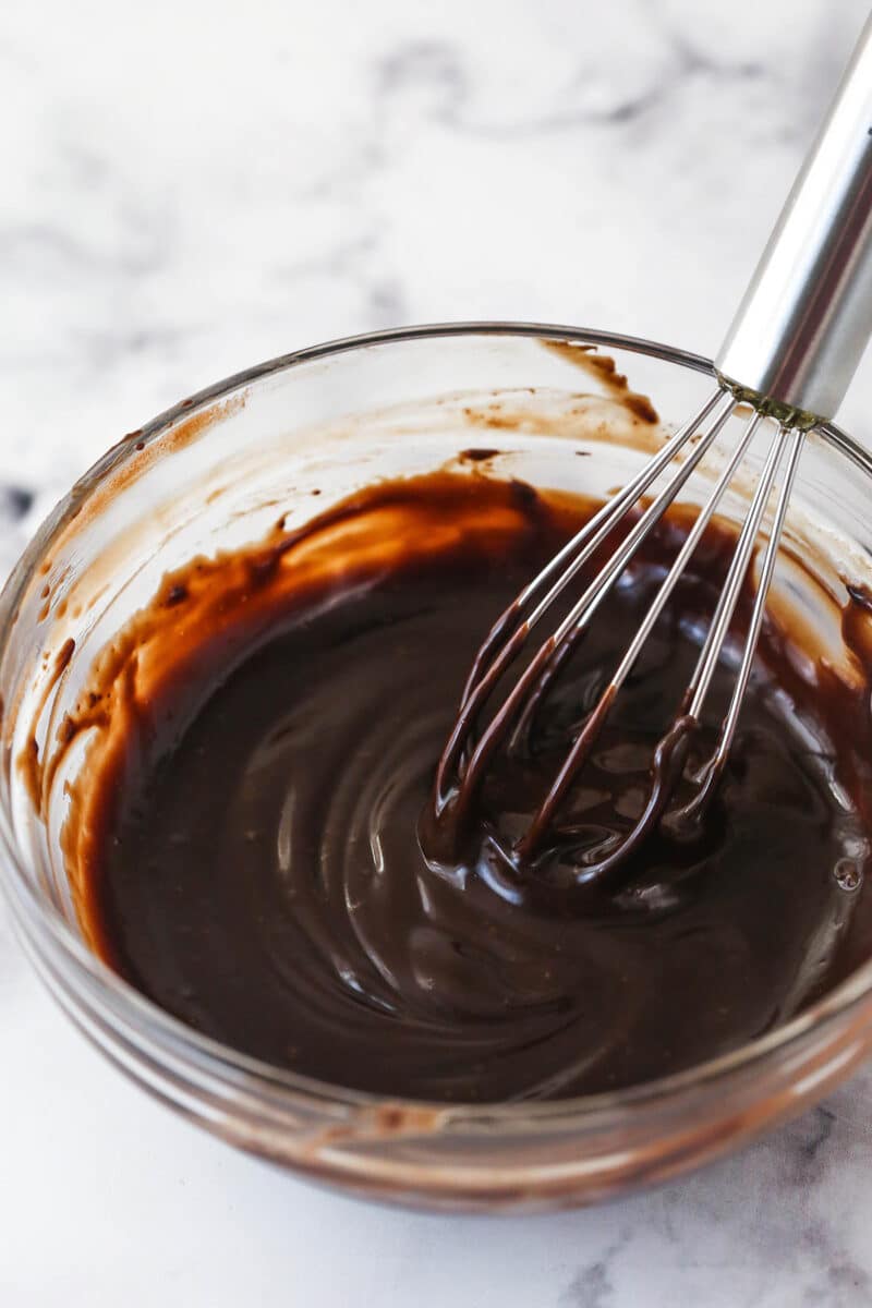 Whisking chocolate ganache in a bowl.