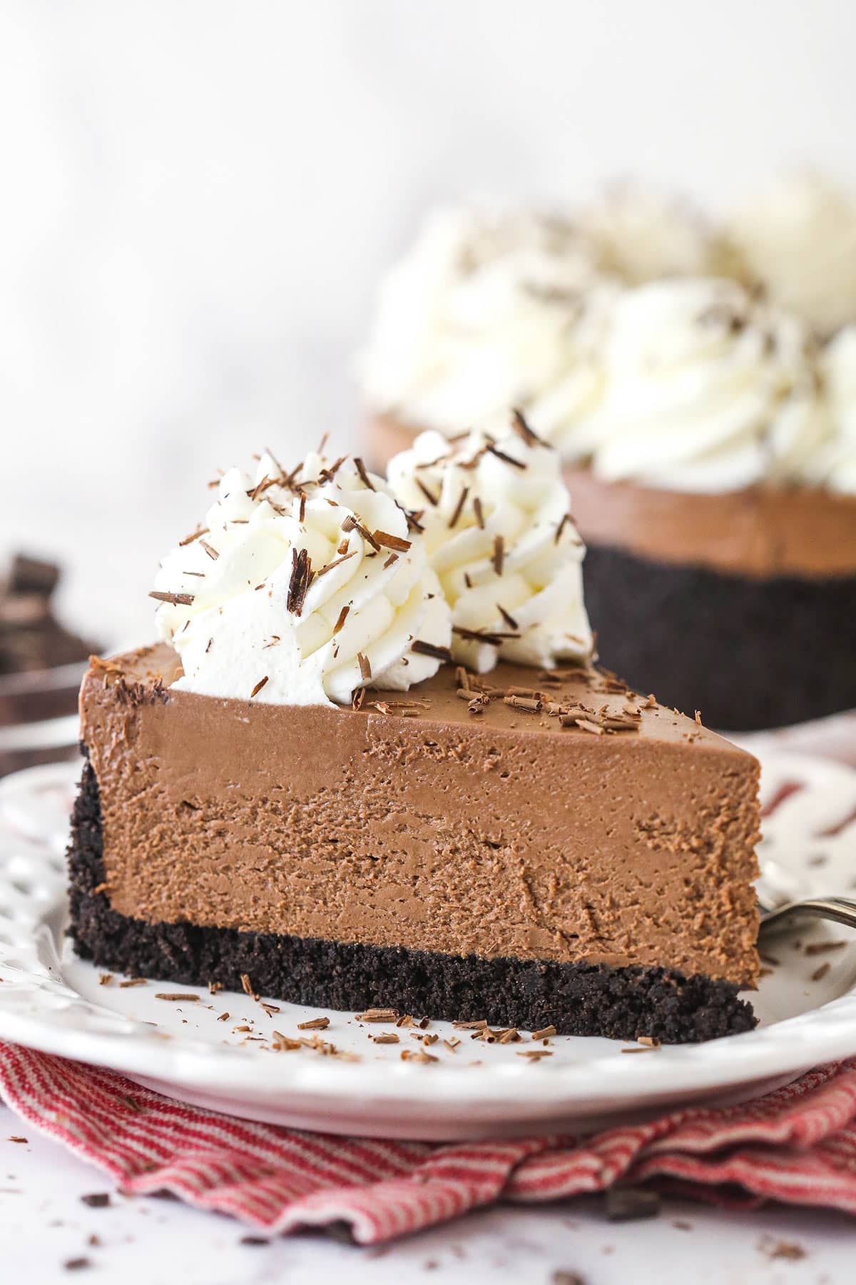 Side view of a slice of No-Bake Chocolate Cheesecake on a white plate.