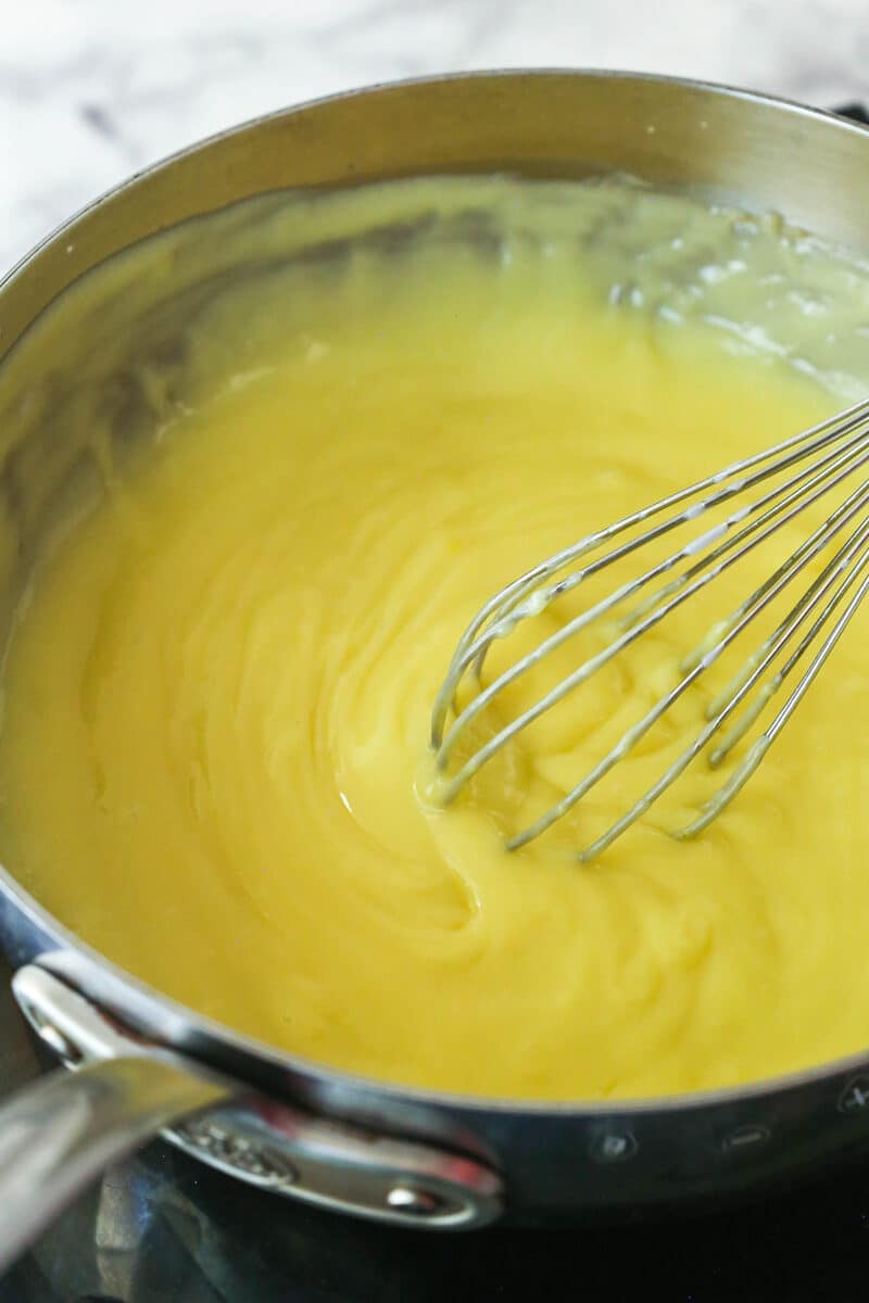 Whisking pastry cream in a saucepan.