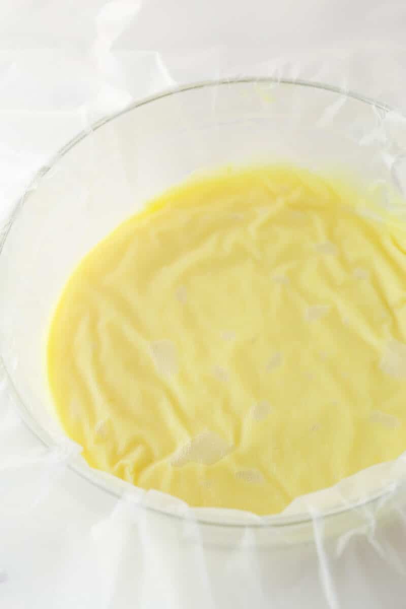 Covering pastry cream with clear wrap.