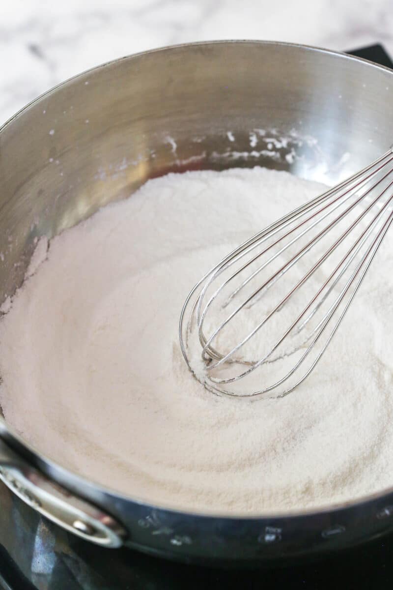 Whisking together cornstarch and sugar, in a saucepan.