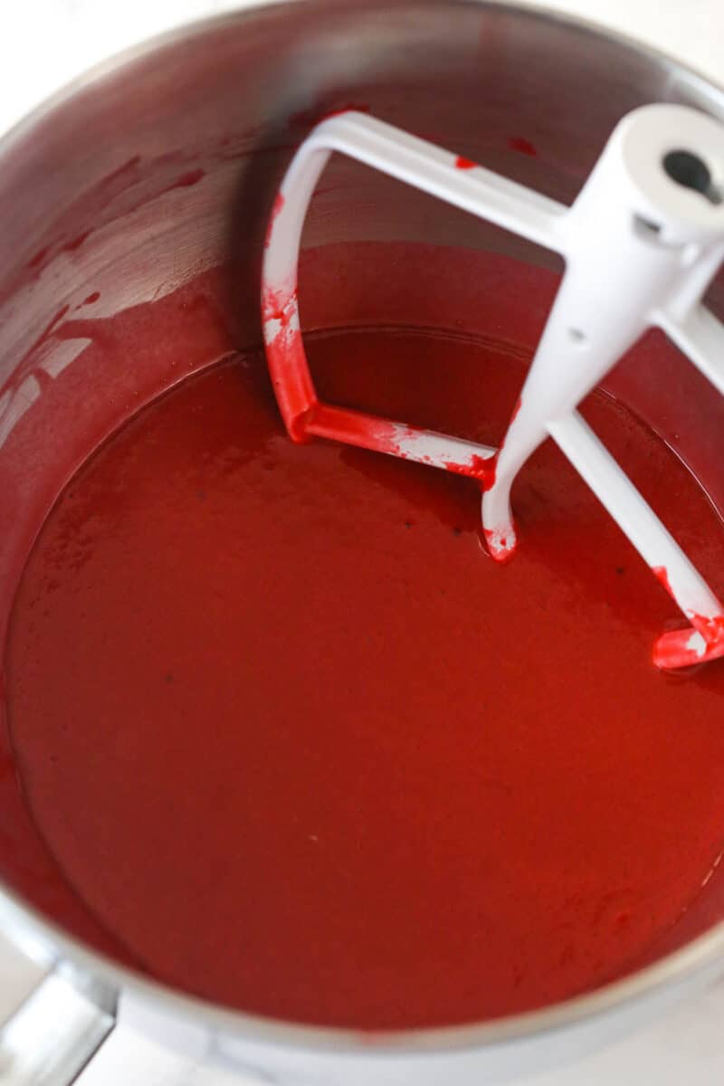 Mixing hot water into red velvet cupcake batter.
