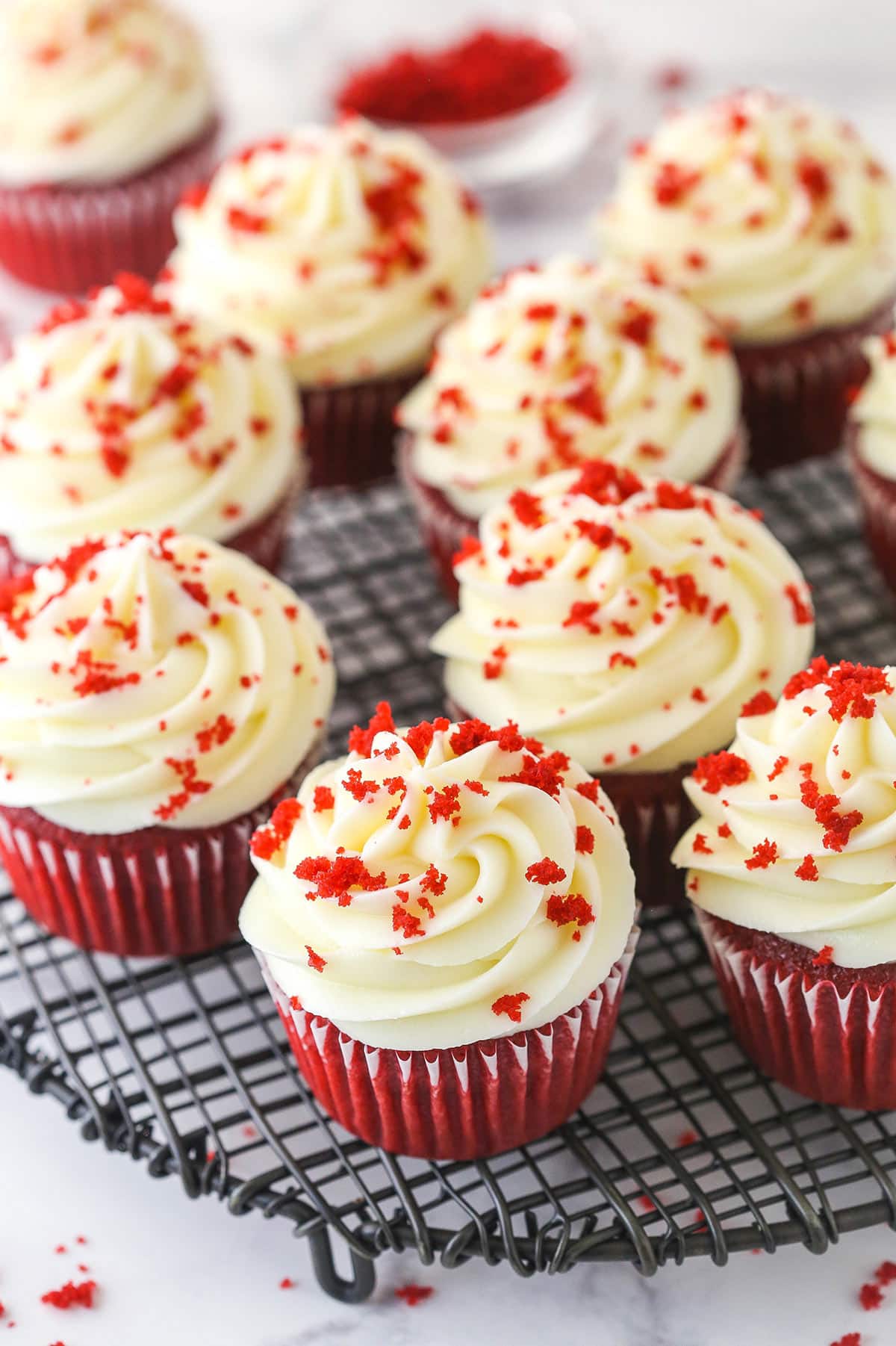 Red velvet cupcakes on a wire rack.