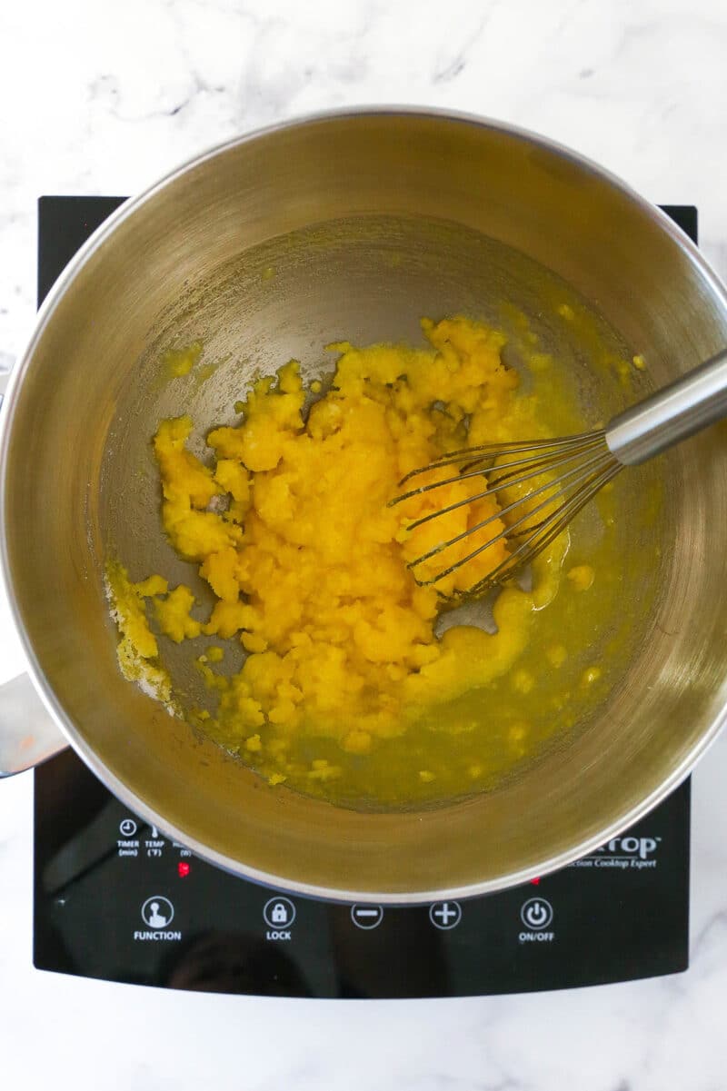 Egg yolk mixture for Strawberry Champagne Tiramisu filling in a metal mixing bowl.