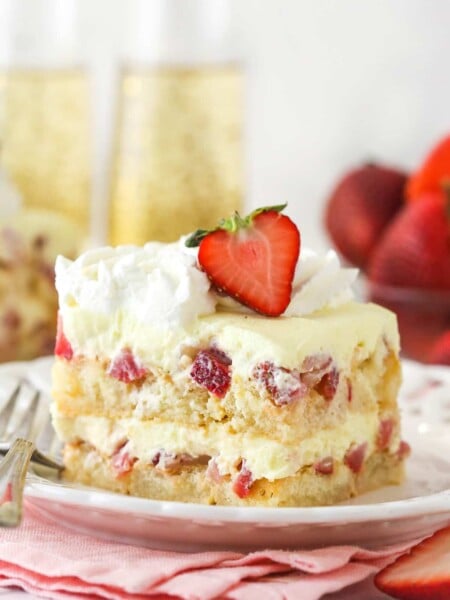 A slice of Strawberry Champagne Tiramisu on a white plate and pink napkin.